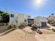 Contemporary home with desert landscaping, neutral stucco exterior, and a dark-stained garage door at 3811 N 64Th St, Scottsdale, AZ 85251