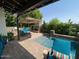 Relaxing backyard patio with a splash pool, built-in barbecue, lounge seating, and lush greenery at 3811 N 64Th St, Scottsdale, AZ 85251