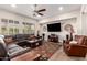 Spacious living room with a ceiling fan, large windows, and comfortable leather seating at 4086 E Narrowleaf Dr, Gilbert, AZ 85298