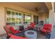 Inviting covered patio with red chairs, ceiling fan, and a cozy fire pit for outdoor relaxation at 4086 E Narrowleaf Dr, Gilbert, AZ 85298