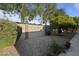 Backyard featuring decorative rock, privacy walls, green trees, and small flowering plants at 445 S Omaha --, Mesa, AZ 85206