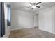 Bedroom features neutral carpet, ceiling fan, white walls, a window with curtains, and a white door at 445 S Omaha --, Mesa, AZ 85206