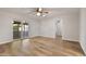 Open room with wood-look floors, a ceiling fan, and a sliding glass door that leads to a bright outdoor area at 445 S Omaha --, Mesa, AZ 85206