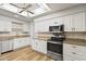 Updated kitchen features white cabinets, stainless steel appliances, granite countertops, and wood look floors at 445 S Omaha --, Mesa, AZ 85206