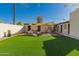 Well-maintained backyard with artificial turf, complemented by a chic patio area covered with a shade awning at 4539 N 9Th Ave, Phoenix, AZ 85013