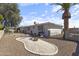 Well-maintained backyard featuring desert landscaping, mature trees, and a wrought iron fence at 5142 E Edgewood Cir, Mesa, AZ 85206