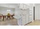 Bright kitchen with an electric cooktop, white cabinets, and a dining area with a wooden table set at 5142 E Edgewood Cir, Mesa, AZ 85206