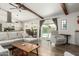 Open-concept living room featuring wood beams, wood-look flooring, and access to the patio at 519 W Palomino Dr, Chandler, AZ 85225