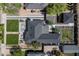 Aerial view of a home with a dark roof, green grass, a patio area, and mature trees at 521 W Cambridge Ave, Phoenix, AZ 85003