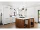Bright kitchen features white cabinets, a wooden island with seating, and pendant lighting at 521 W Cambridge Ave, Phoenix, AZ 85003