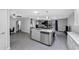 Open living space with kitchen island, stainless appliances, and seating, connecting all areas of the home at 5342 S Farmer Ave, Tempe, AZ 85283