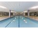 Spacious indoor pool with abundant natural light, surrounded by lounge chairs and a fitness center at 7157 E Rancho Vista Dr # 3009, Scottsdale, AZ 85251