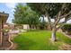 View of a expansive backyard featuring trees, a grassy lawn, patio space, and block wall fencing at 7254 E Vernon Ave, Scottsdale, AZ 85257