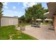 Spacious backyard with a large patio, dining set, mature trees, and a storage shed at 7254 E Vernon Ave, Scottsdale, AZ 85257
