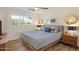 Bright bedroom featuring a ceiling fan, wood floors, modern decor, and a sunlit window at 7254 E Vernon Ave, Scottsdale, AZ 85257
