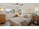 Sunlit bedroom with ceiling fan, plush bedding, wood-look floors, and stylish furnishings at 7254 E Vernon Ave, Scottsdale, AZ 85257