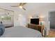 Cozy bedroom with ceiling fan, patterned bedding, closet and adjacent modern bathroom at 7254 E Vernon Ave, Scottsdale, AZ 85257
