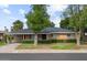Lovely single-story brick home featuring a green lawn, trimmed hedges, and mature trees at 7254 E Vernon Ave, Scottsdale, AZ 85257