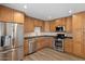 Well-lit kitchen features stainless steel appliances, wood cabinets, and granite countertops at 7254 E Vernon Ave, Scottsdale, AZ 85257