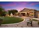 This backyard features a putting green, a fireplace, outdoor dining, and a covered patio with string lights at 7471 E Desert Vista Rd, Scottsdale, AZ 85255