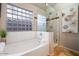 Bright bathroom featuring a bathtub and separate glass shower, with decorative tile and natural light at 7471 E Desert Vista Rd, Scottsdale, AZ 85255