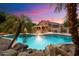 Backyard with an in-ground pool, stone accents, and palm trees at dusk at 7471 E Desert Vista Rd, Scottsdale, AZ 85255