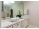 Bathroom featuring double vanity sinks, modern fixtures, and a well-lit mirror at 8100 E Camelback Rd # 138, Scottsdale, AZ 85251