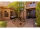 Inviting outdoor area featuring lush landscaping, a cozy seating area, and a charming brick walkway at 8100 E Camelback Rd # 138, Scottsdale, AZ 85251