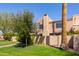 Exterior view of a home with desert landscaping, mature trees, a lawn, and a gated entry at 8100 E Camelback Rd # 138, Scottsdale, AZ 85251