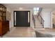 Bright foyer features hardwood floors, a staircase with rod iron railing and a decorative light fixture at 8100 E Camelback Rd # 138, Scottsdale, AZ 85251