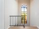 A light-filled hallway with a modern lighting fixture and a view to the outside through an arched window at 8100 E Camelback Rd # 138, Scottsdale, AZ 85251