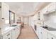 Modern white kitchen with long counters, stainless steel appliances, and a view to the outdoors at 8100 E Camelback Rd # 138, Scottsdale, AZ 85251