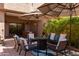 Covered patio has an outdoor seating area with a fire pit, stylish furniture and lush greenery at 8100 E Camelback Rd # 138, Scottsdale, AZ 85251