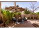 Charming patio with an umbrella covered conversation set surrounded by greenery and potted plants at 8100 E Camelback Rd # 138, Scottsdale, AZ 85251