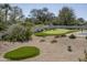 A backyard with a putting green, pickle ball court, lush landscaping, and mature shade trees at 8817 N 58Th Pl, Paradise Valley, AZ 85253