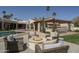 Backyard view showcases a fire pit, pool, manicured lawn, and an outdoor kitchen area at 8817 N 58Th Pl, Paradise Valley, AZ 85253