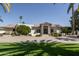 Expansive single-story home with a circular driveway and mature landscaping with palm trees at 8817 N 58Th Pl, Paradise Valley, AZ 85253