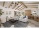 Bright living room boasts vaulted ceilings with beams, modern light fixtures, and cozy seating arrangement at 8817 N 58Th Pl, Paradise Valley, AZ 85253
