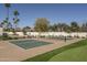 A pickleball court surrounded by lush green grass, mature trees, and serene landscaping at 8817 N 58Th Pl, Paradise Valley, AZ 85253