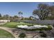 This home offers a backyard with a putting green, a sand trap, and mature palm trees at 8817 N 58Th Pl, Paradise Valley, AZ 85253