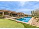 Serene backyard with pool, putting green, outdoor kitchen, and ample seating for relaxation and entertainment at 9440 N Sunset Rdg, Fountain Hills, AZ 85268