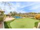Scenic backyard with lush landscaping, pool, putting green, and mountain views at 9440 N Sunset Rdg, Fountain Hills, AZ 85268