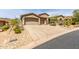 Exterior view of a luxury home with a three car garage and desert landscaping at 9440 N Sunset Rdg, Fountain Hills, AZ 85268