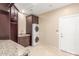 Well-lit laundry room featuring stacked washer/dryer, granite counters, and ample storage at 9440 N Sunset Rdg, Fountain Hills, AZ 85268