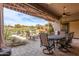 Inviting covered patio with stone pavers, fan, and views of lush landscaping and pool at 9440 N Sunset Rdg, Fountain Hills, AZ 85268