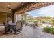 Inviting covered patio with stone pavers, fan, and views of lush landscaping and pool at 9440 N Sunset Rdg, Fountain Hills, AZ 85268