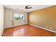 Bright bedroom with hardwood floors, ceiling fan, and a window offering neighborhood views at 10843 E Kilarea Ave, Mesa, AZ 85209