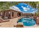 Beautiful backyard showcasing a sparkling pool, covered patio, and lush landscaping, perfect for relaxing at 13146 S 178Th Ave, Goodyear, AZ 85338