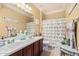 Well-lit bathroom features double sinks, a decorative shower curtain, and neutral color scheme at 13146 S 178Th Ave, Goodyear, AZ 85338
