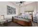 Cozy bedroom featuring a wooden bed frame, ceiling fan and a large window for natural light at 13146 S 178Th Ave, Goodyear, AZ 85338